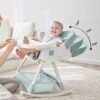 Silla mecedora con babero, vaso entrenador y plato de comida